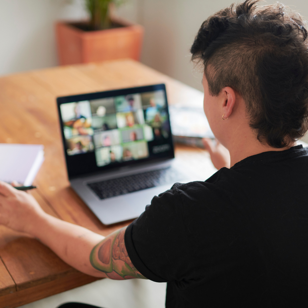 Person viewing a computer screen displaying a grid of images, likely in an online grief support group.