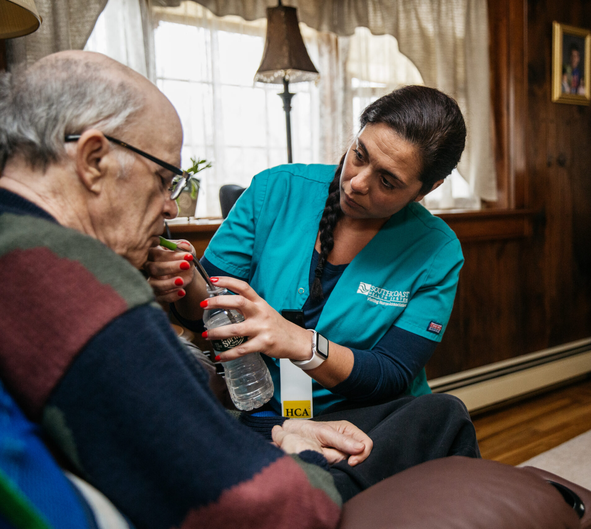 Provider giving water to patient